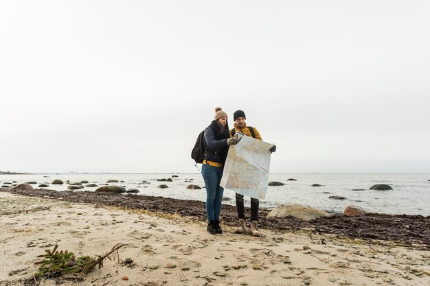 Pareja con mapa en la costa