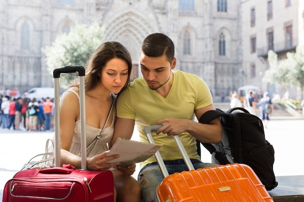 Foto gratuita pareja con el mapa de lectura de equipaje