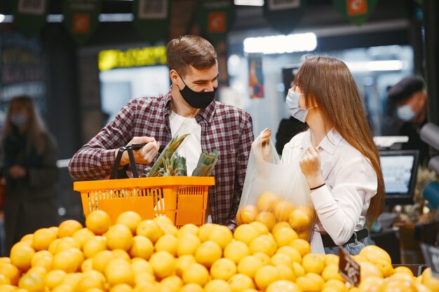 Pareja en máscara protectora médica en un supermercado.