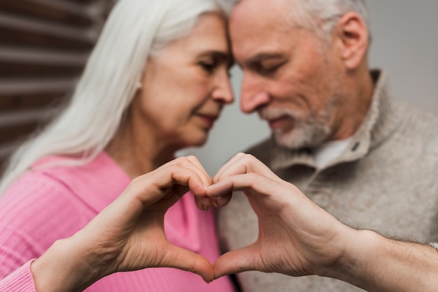 Foto gratuita pareja mayor, actuación, forma corazón, de, manos