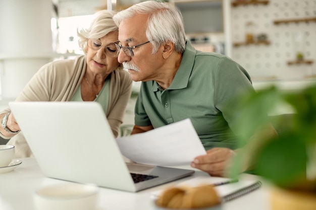 Pareja mayor analizando sus ahorros mientras revisa las finanzas del hogar