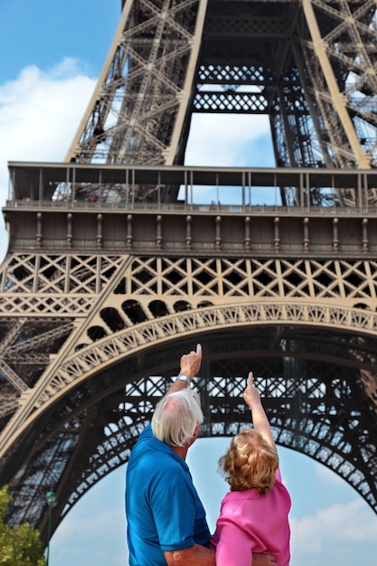 Pareja mayor apuntando a la torre eiffel