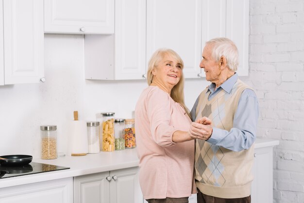 Pareja mayor bailando en cocina