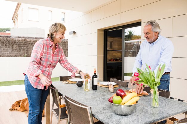 Pareja mayor desayunando en jardín