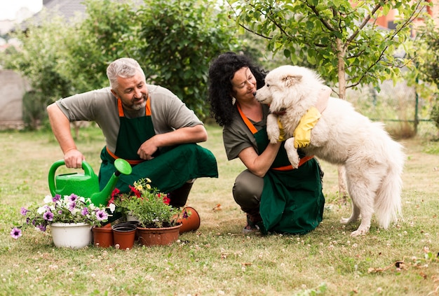 Pareja mayor, en jardín, con, un, perro