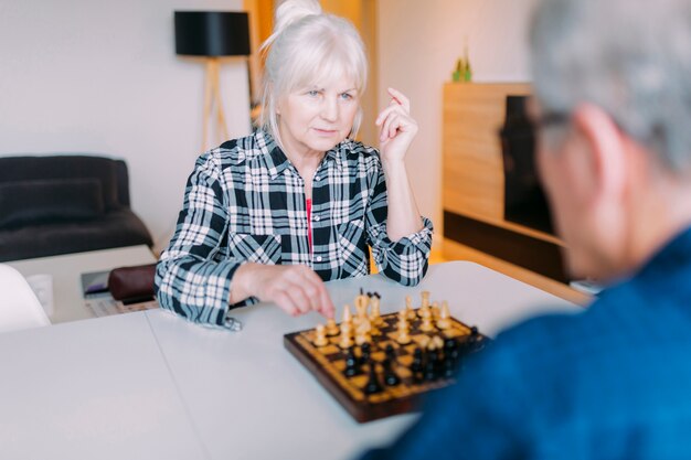 Pareja mayor jugando ajedrez en casa de ancianos