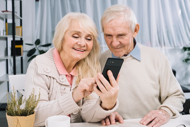 Pareja mayor mirando a smartphone