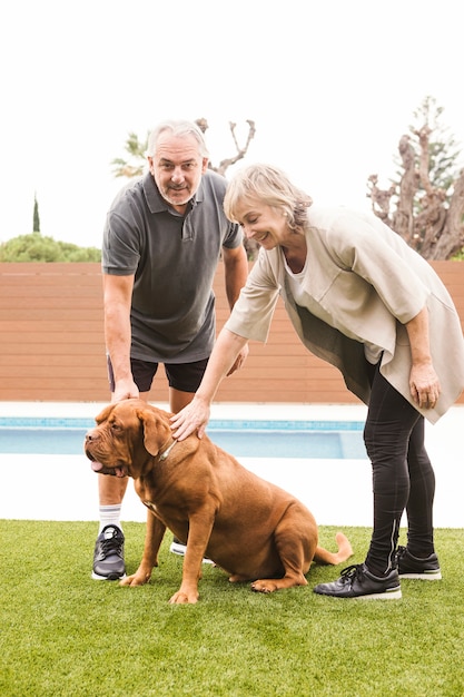 Pareja mayor con perro en jardín