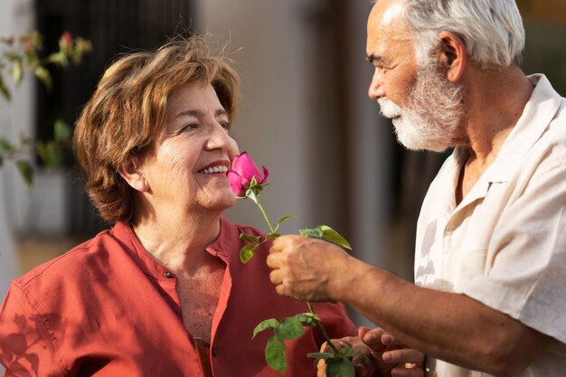 Pareja mayor romántica en su casa de campo con flores