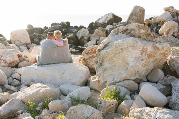 Pareja mayor, sentado, en, rocas, vista trasera