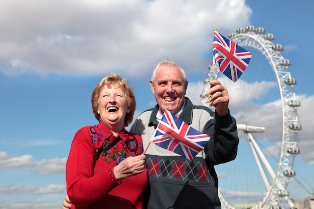 Foto gratuita pareja mayor sosteniendo la bandera británica en londres
