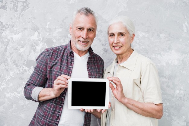 Pareja mayor sosteniendo una tablet