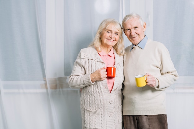 Foto gratuita pareja mayor con tazas de café