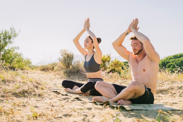 Pareja meditando juntos por la playa