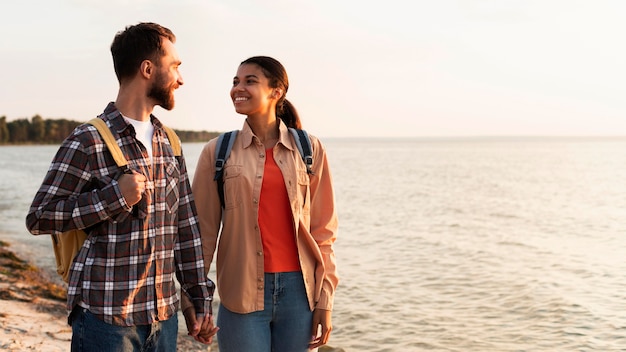 Pareja mirando el uno al otro mientras da un paseo junto al mar