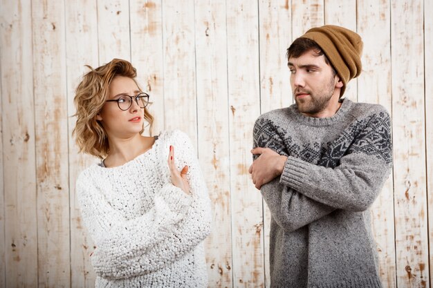 Pareja mirando el uno al otro sobre pared de madera Chica rechazar.