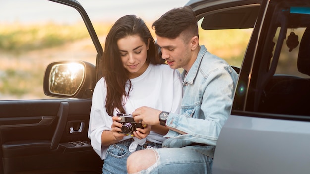 Foto gratuita pareja mirando fotos en un viaje por carretera