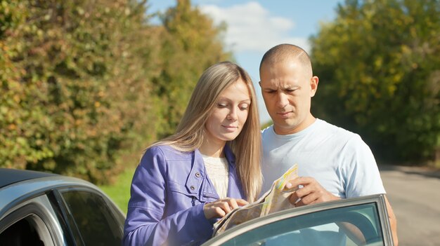 Pareja mirando el mapa en la carretera