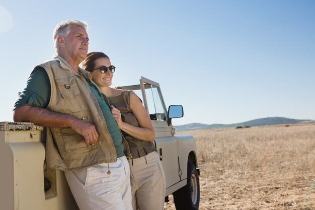 Pareja mirando a otro lado mientras está parado en vehículo en el campo