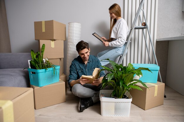 Pareja mirando sus pertenencias después de mudarse a una casa nueva