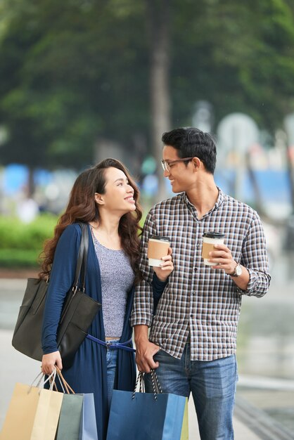 Pareja mirándose con amor sosteniendo bolsas de compras