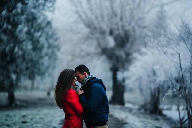 Pareja mirándose de cerca a los ojos con un fondo nevado desenfocado