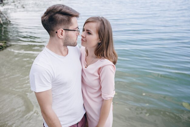 Pareja mirándose a los ojos con el mar de fondo