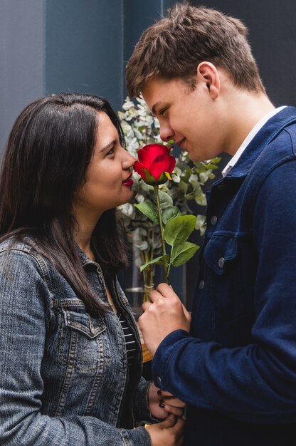 Pareja mirándose a los ojos con una rosa en medio