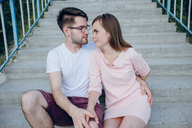 Pareja mirándose a los ojos sentados en una escalera