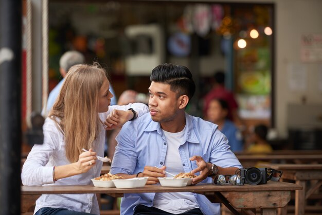 Pareja mixta en café al aire libre