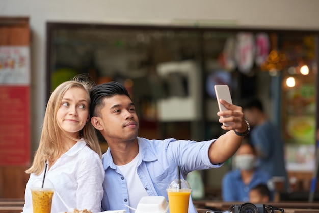 Pareja mixta tomando selfie