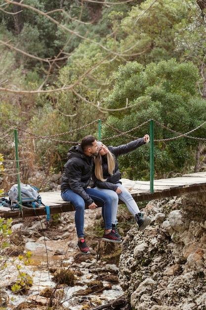 Pareja, con, mochila, sentado, en, puente