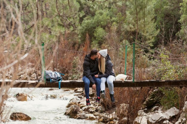 Pareja, con, mochila, sentado, en, puente