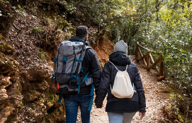 Pareja con mochilas en la naturaleza de cerca