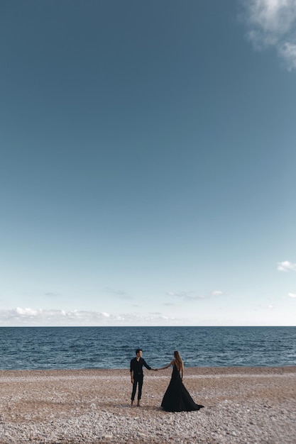 pareja de moda con vestido negro y traje al aire libre