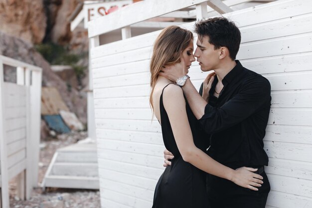 pareja de moda con vestido negro y traje al aire libre