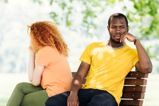 Foto gratuita pareja molesta sentada en el parque