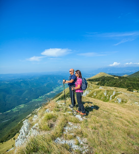 Pareja de montañeros en la meseta de Nanos en Eslovenia mirando el hermoso valle de Vipava