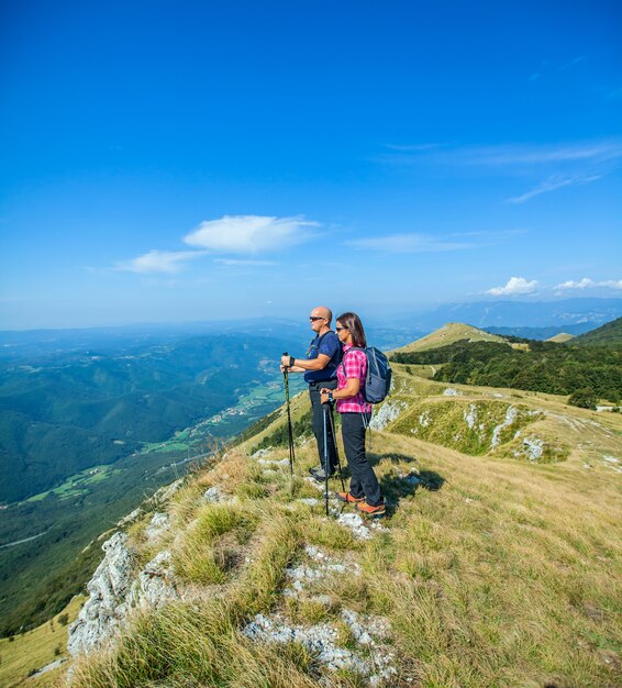 Pareja de montañeros en la meseta de Nanos en Eslovenia mirando el hermoso valle de Vipava