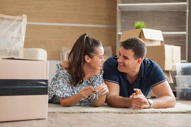 Pareja mostrando las llaves de una casa nueva.