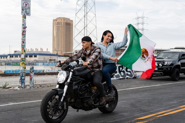 Pareja en moto con bandera mexicana