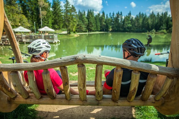 Pareja de motociclistas en un recorrido por el lago Bloke descansando sobre un columpio de madera