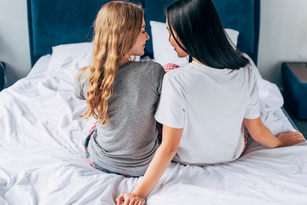 Foto gratuita pareja de mujeres sentadas en la cama