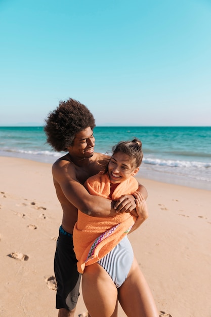 Pareja multicultural divirtiéndose en la playa