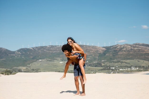 Pareja multiétnica divirtiéndose en la playa