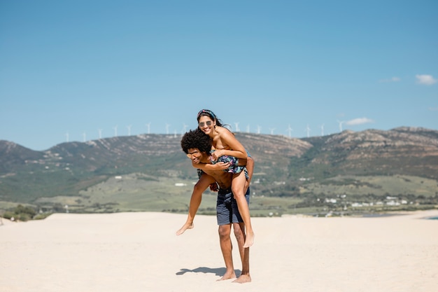 Pareja multiétnica divirtiéndose en la playa