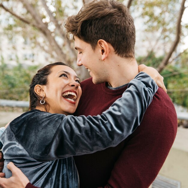 Pareja multirracial abrazando y sonriendo