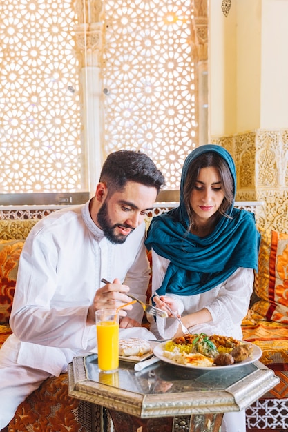 Pareja musulmana comiendo en restaurante arabe