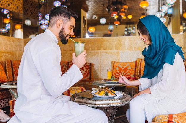 Pareja musulmana comiendo en restaurante arabe