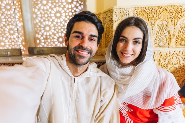 Foto gratuita pareja musulmana haciendo selfie en restaurante